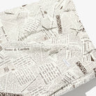 Newspaper print fabric with text and logos on a white background