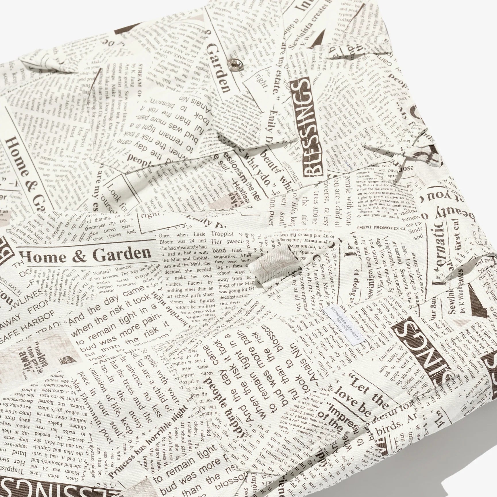 Newspaper print fabric with text and logos on a white background