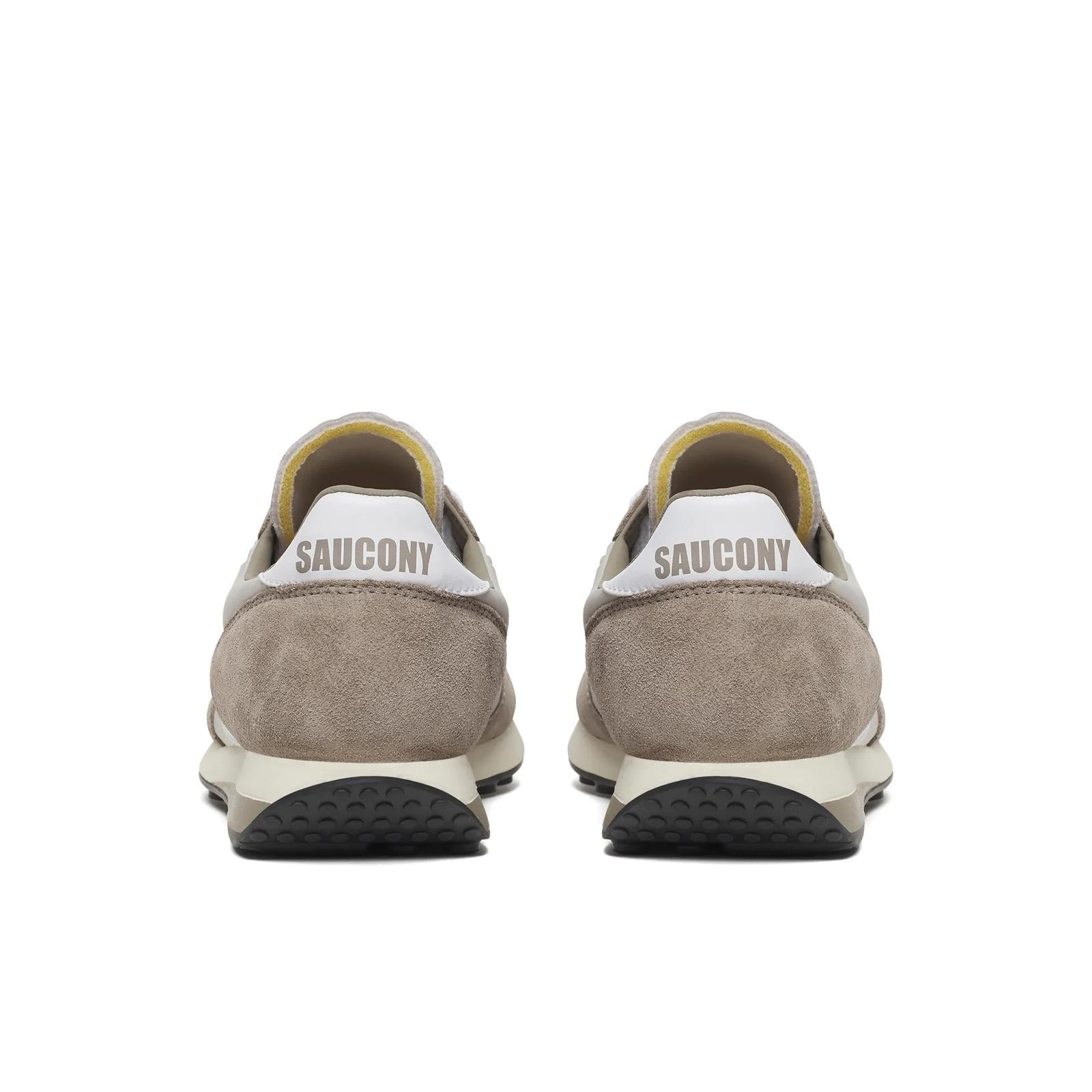 Pair of beige Saucony sneakers on a white background