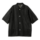 Black textured shirt with white buttons on a white background