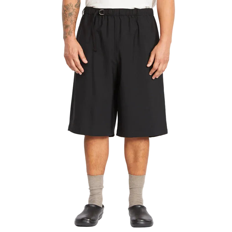 Person wearing black shorts on a white background