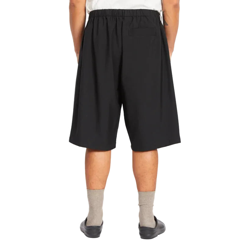 Person wearing black shorts on a white background