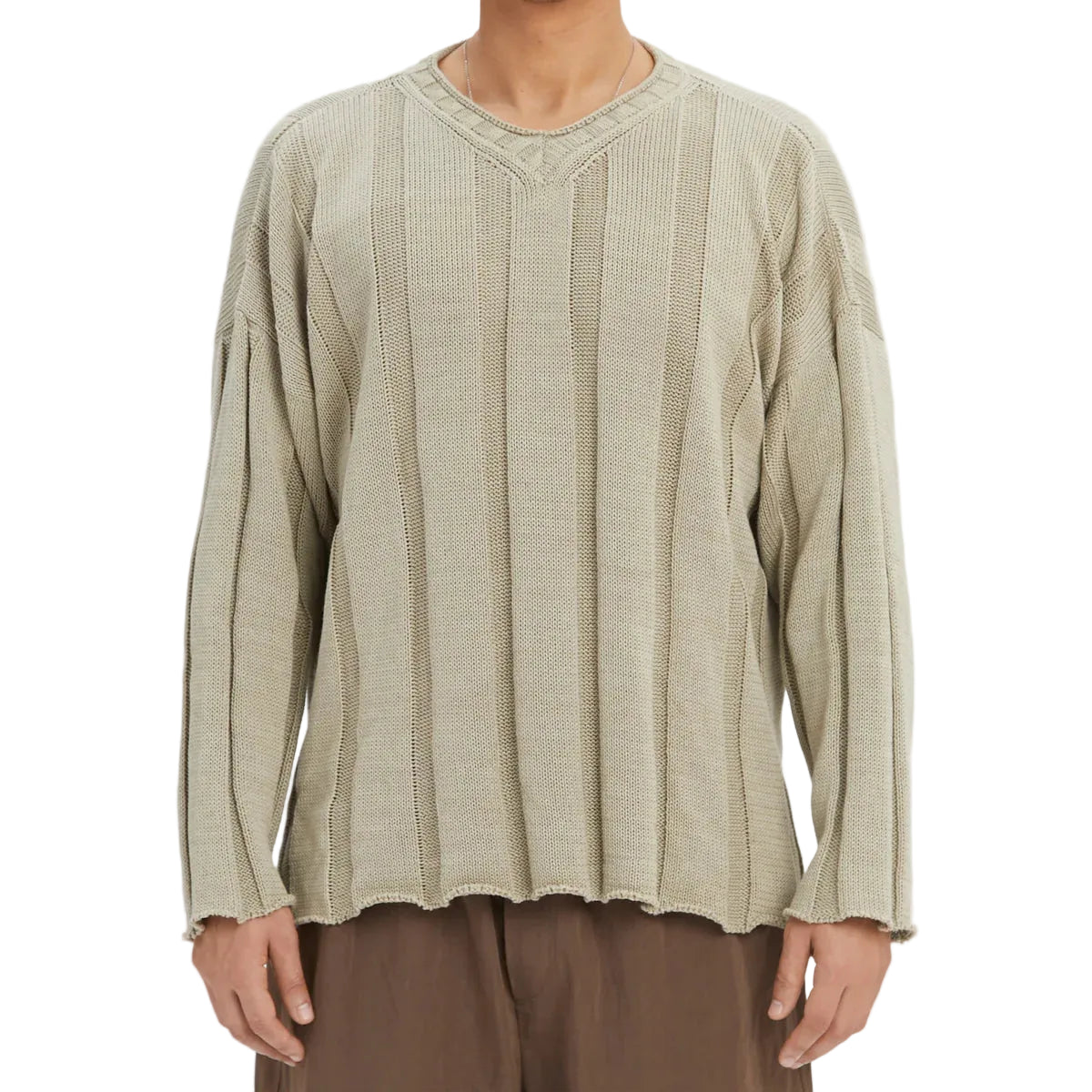 Person wearing a textured beige long-sleeve sweater on a white background
