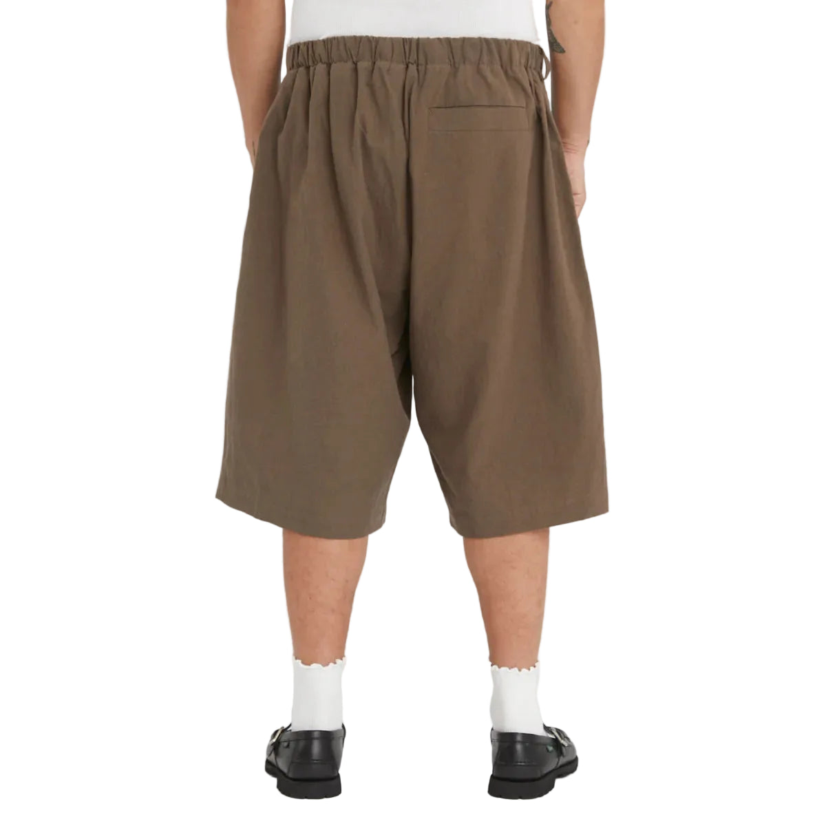Brown shorts worn by a person on a white background
