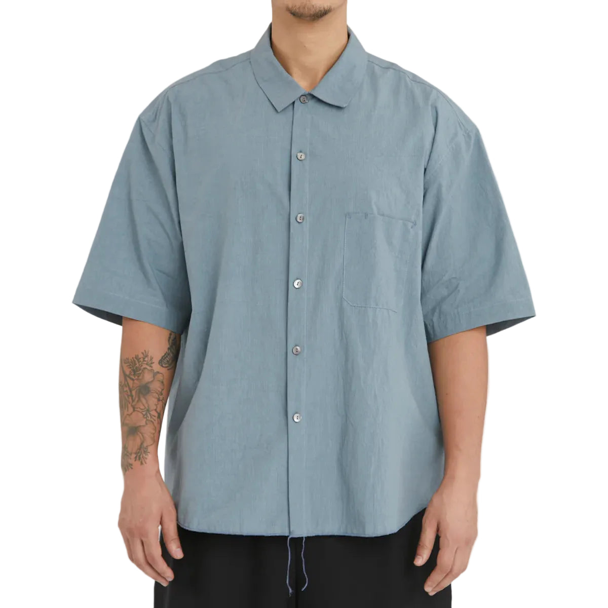 Person wearing a light blue short-sleeve shirt on a white background