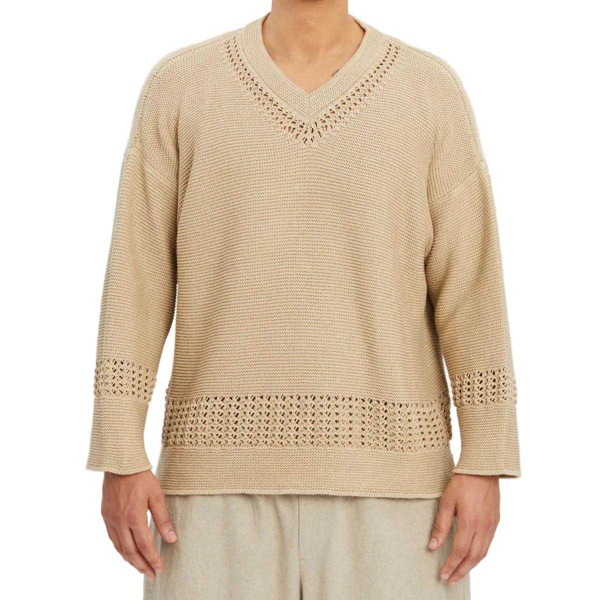 Beige sweater with intricate patterns on a plain background