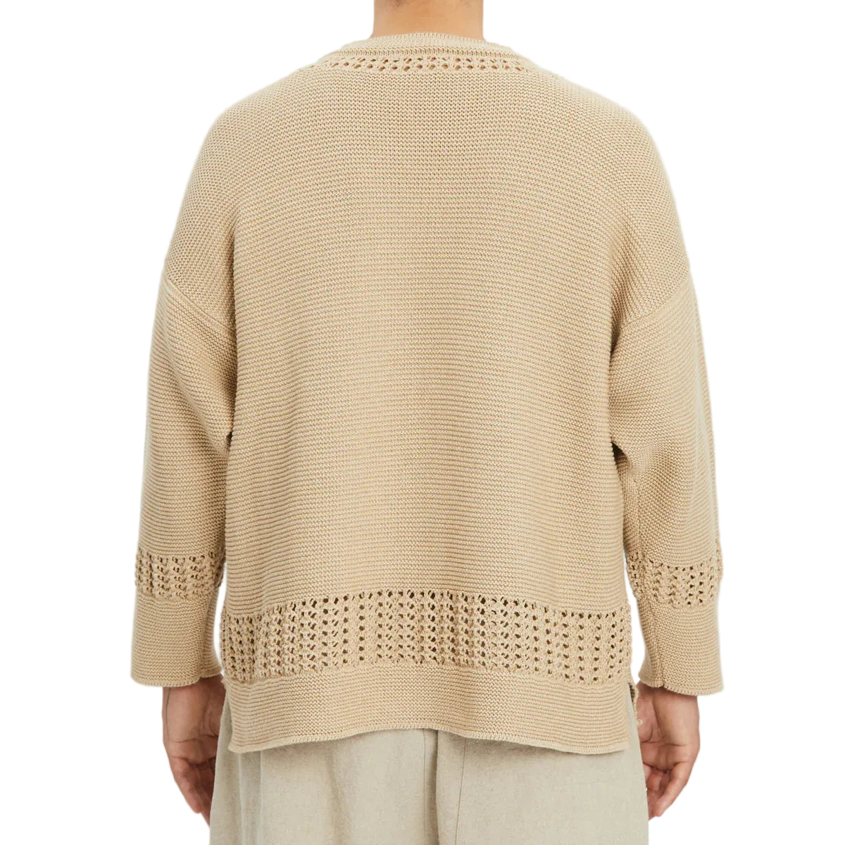 Beige knitted sweater worn by a person on a white background