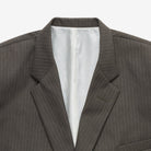 Gray pinstripe suit jacket with white lining on a light gray background