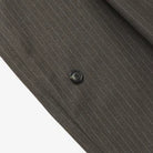 Close-up of a dark gray pinstripe fabric with a button on a white background