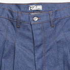 Close-up of blue denim pants with a brand label on the pocket.