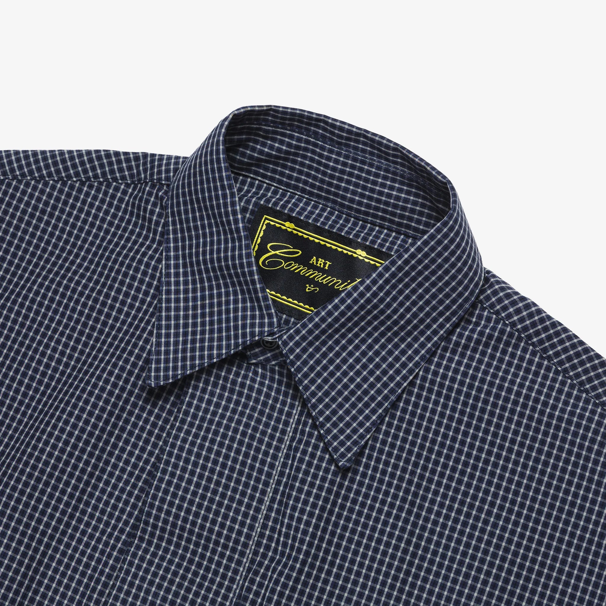 Close-up of a navy checkered shirt with a brand label on a white background