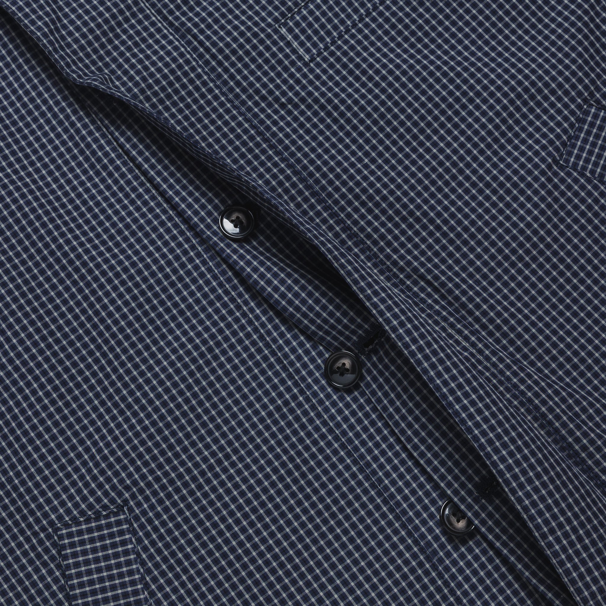 Close-up of a dark blue checkered shirt with buttons