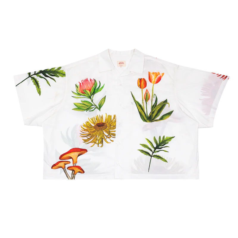 White shirt with colorful floral and mushroom designs on a white background