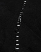Close-up of white stitching on black fabric
