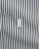 Close-up of a black and white striped fabric with a brand logo.