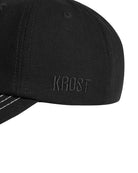 Black cap with 'KROST' branding on a white background