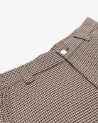 Close-up of a brown and black checkered fabric with a button on a light background