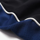 Close-up of black and blue fabric with white trim on a white background