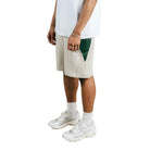 Person wearing a white t-shirt and beige shorts on a white background