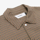 Houndstooth patterned shirt with a visible brand label on a white background