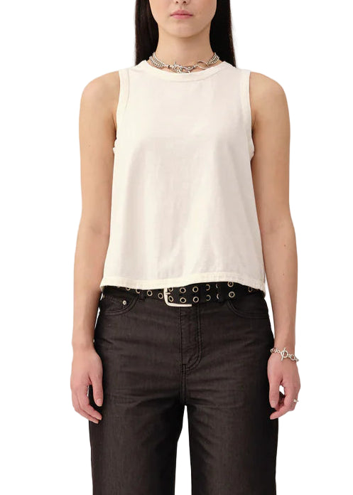 Woman wearing a white sleeveless top and dark pants on a white background