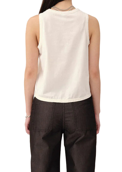 Person wearing a white sleeveless top and dark pants on a white background