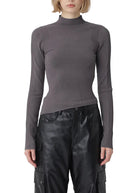 Person wearing a gray turtleneck and black leather pants on a white background