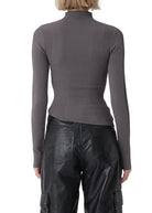 Person wearing a gray long-sleeve top and black leather pants on a white background