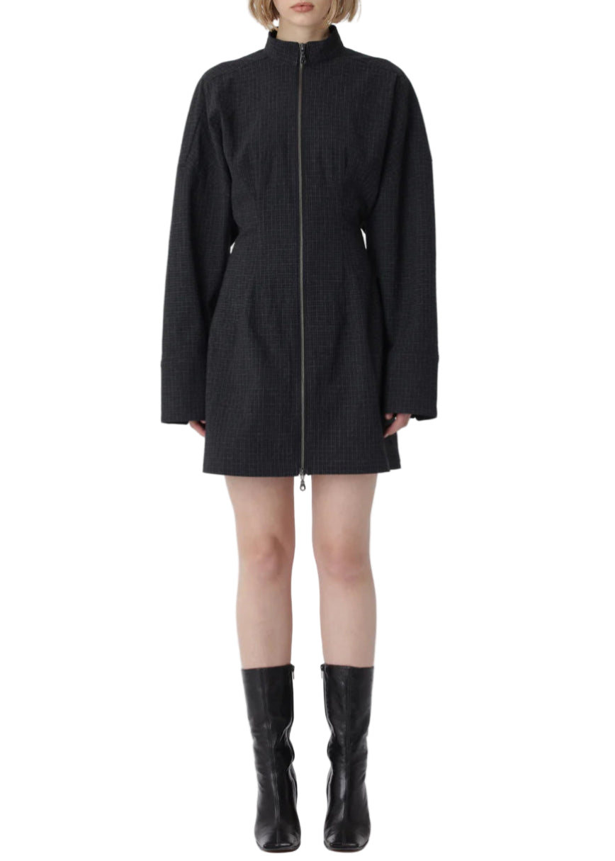 Person wearing a black dress and boots on a white background