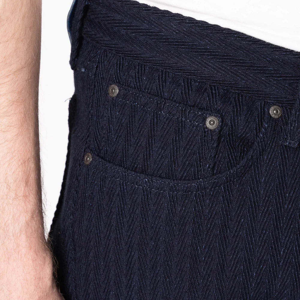 Close-up of dark blue corduroy pants with a white background