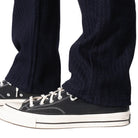 Navy pants with black sneakers on a white background