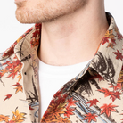 Close-up of a person wearing a patterned shirt with a neutral background