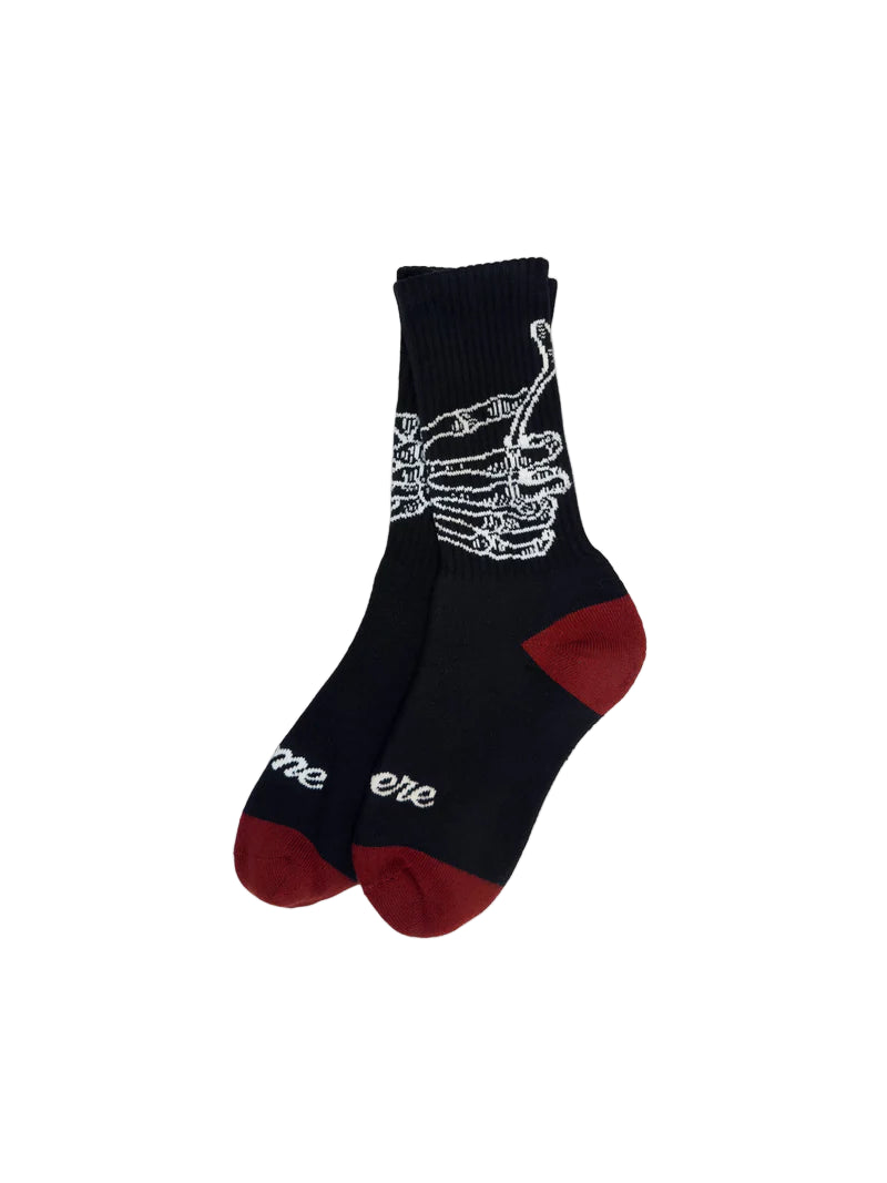 Black sock with skeleton hand design and red toes on a white background