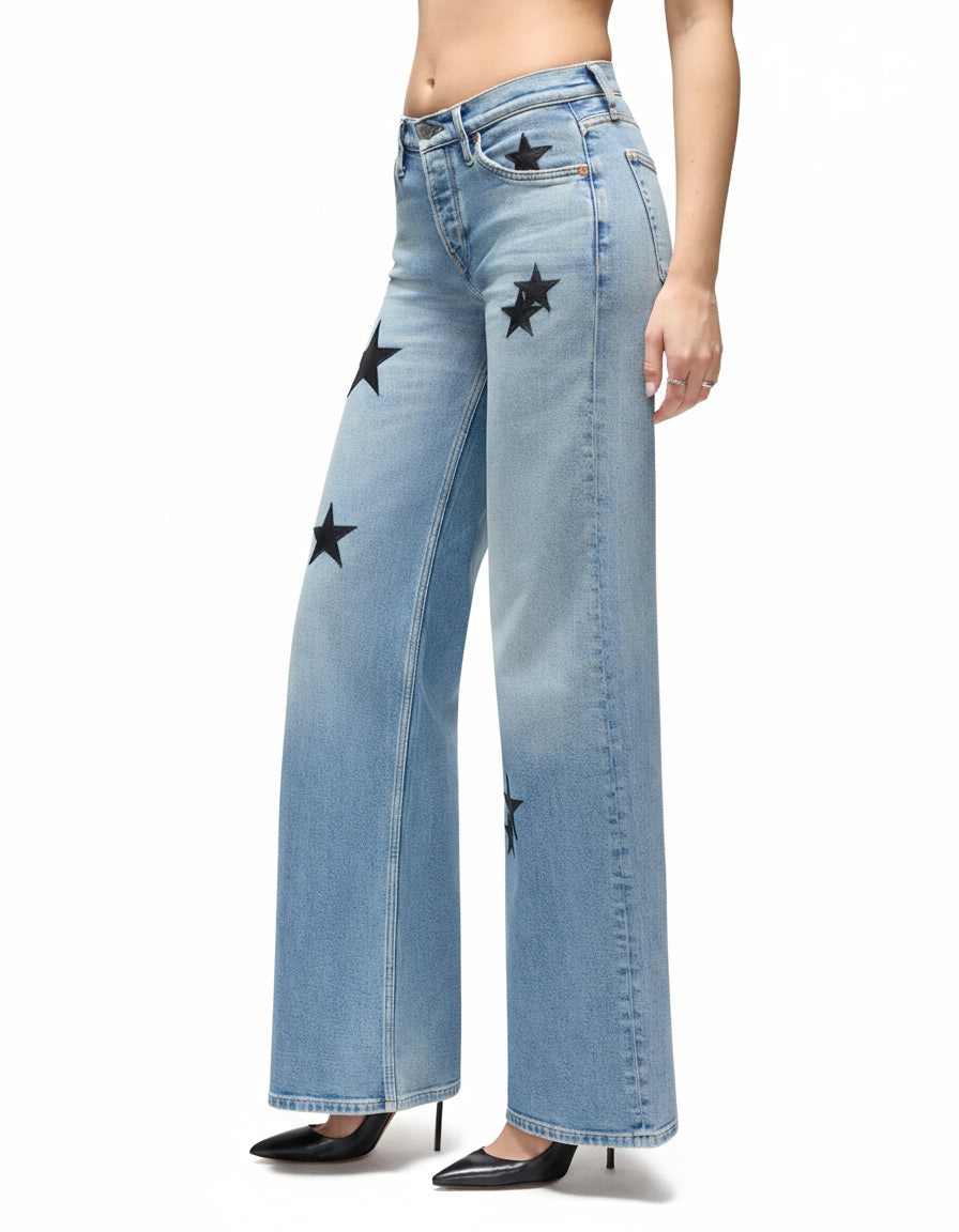 Light blue jeans with star patterns worn by a person on a white background