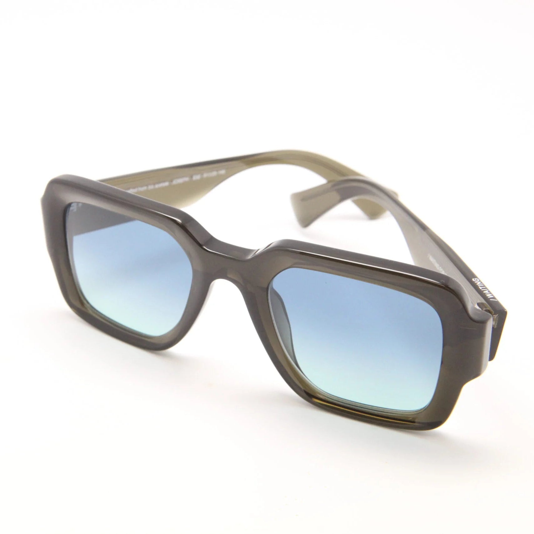 Sunglasses with a gray frame and blue gradient lenses on a white background