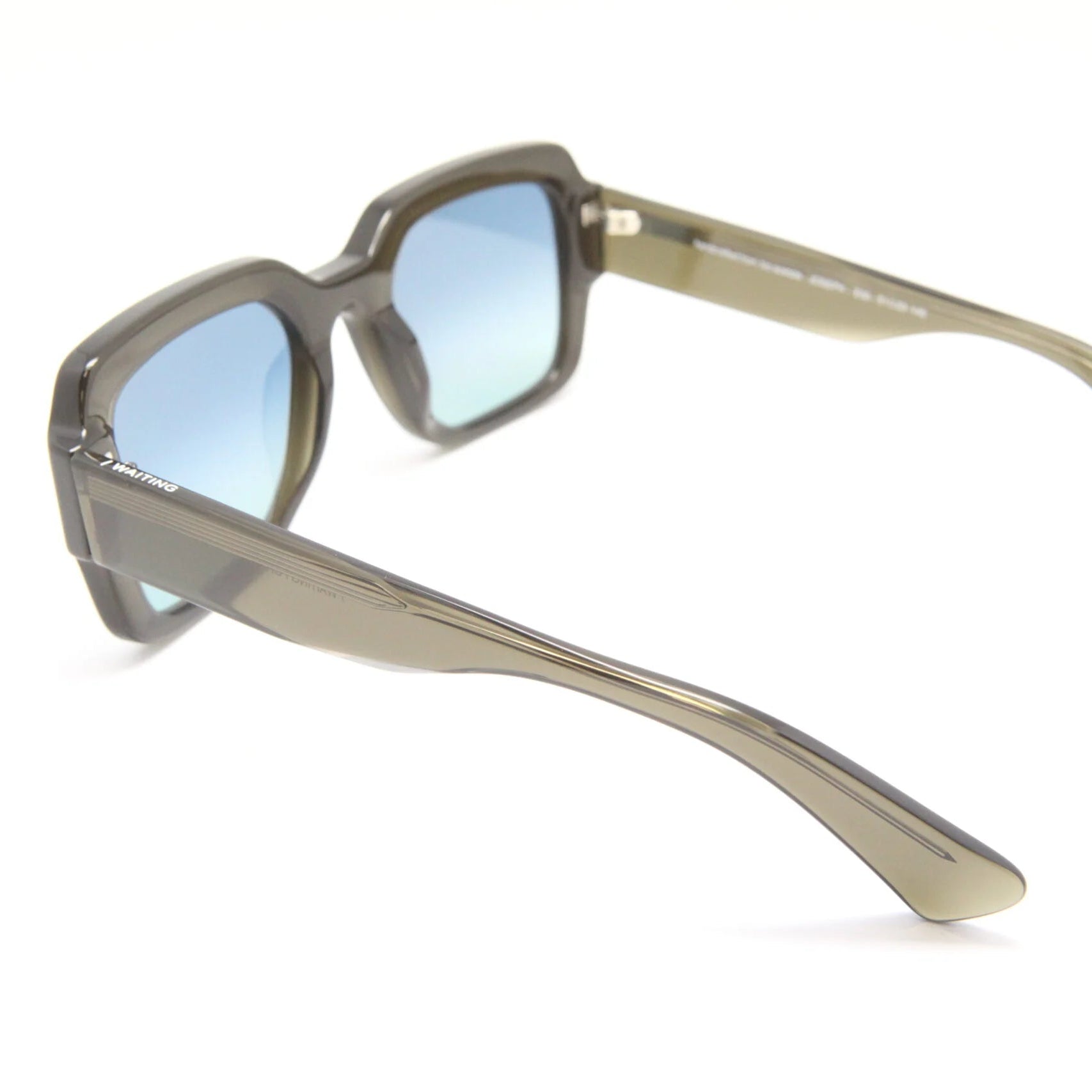 Sunglasses with a clear frame and blue-tinted lenses on a white background