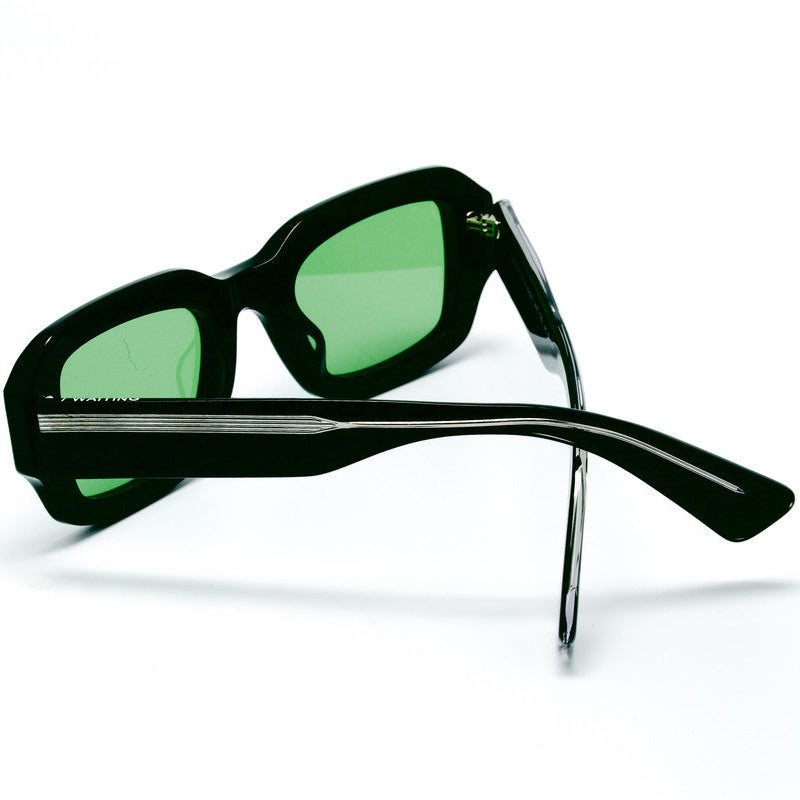 Black sunglasses with green lenses on a white background