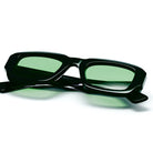 Black glasses with green lenses on a white background