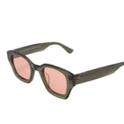 Sunglasses with pink lenses and green frames on a white background
