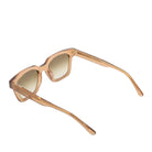 Sunglasses with gold frame and light-colored lenses on a white background