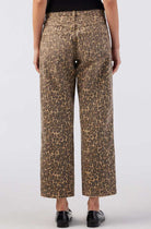 Leopard print pants worn by a person on a white background