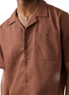 Brown button-up shirt worn by a person with a gold necklace.