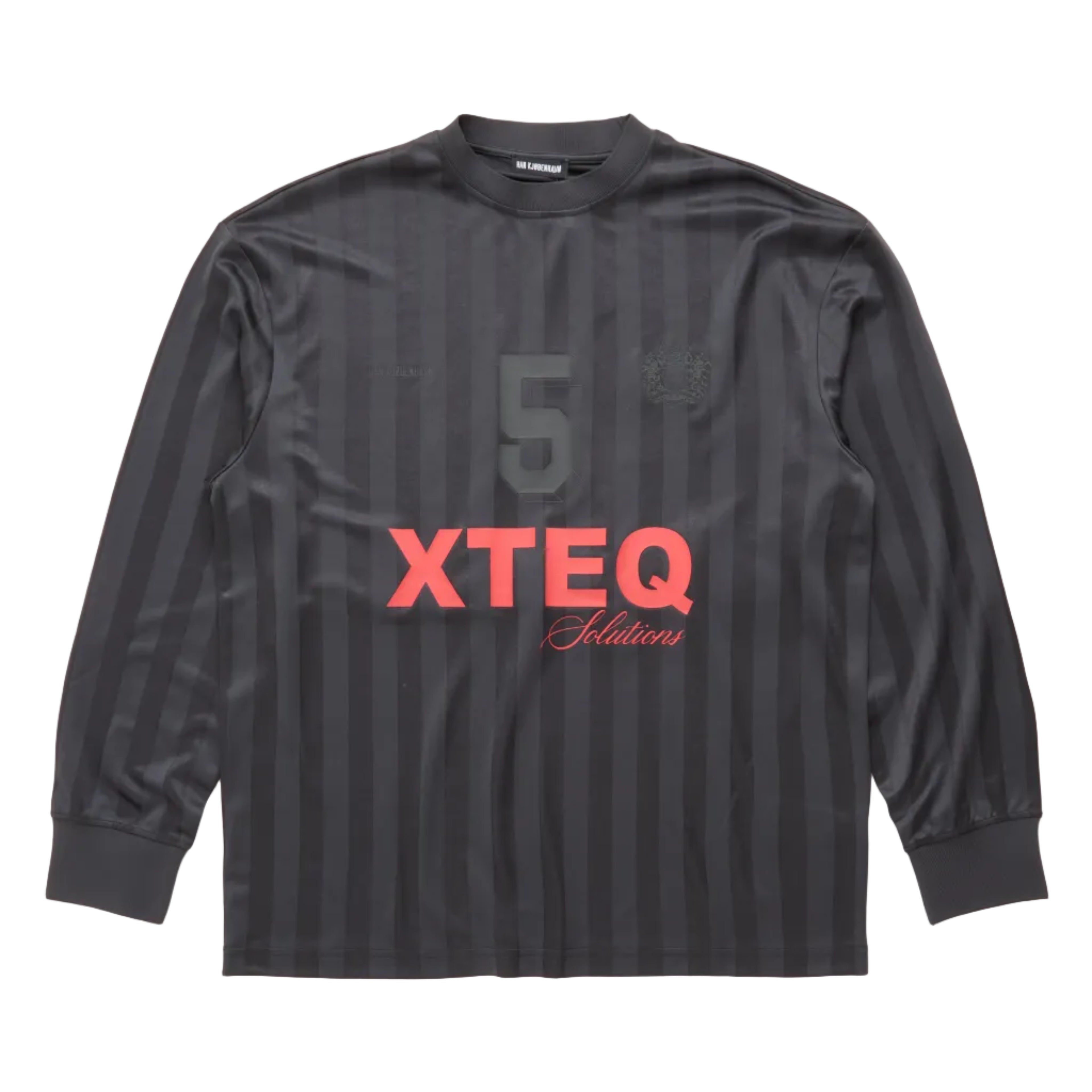 A dark gray long-sleeve soccer jersey with vertical stripes, featuring a large gray number 5 on the chest, a small crest, and 'XTEQ' printed in coral red with cursive below it, laid flat against a white background.