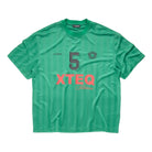 A green short-sleeve athletic t-shirt with vertical stripes, featuring a large gray number 5 on the chest, 'XTEQ' in coral pink text, and a small crest logo, laid flat against a white background.