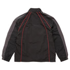 Black and gray athletic windbreaker jacket shown from the back, featuring red piping details along the seams, set against a plain white background.