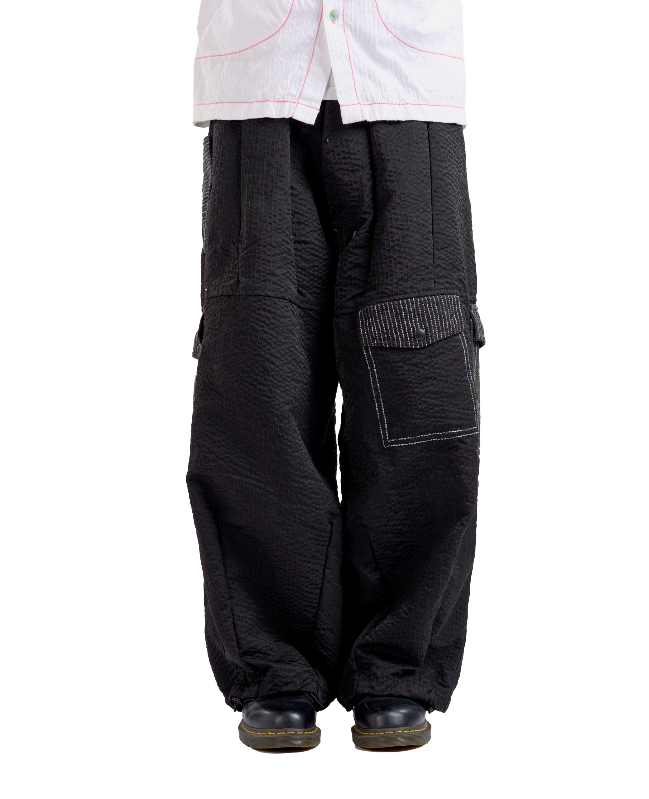 Black baggy pants worn by a person on a white background
