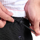 Person adjusting a black bungee adjustment on a white background