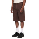 Man wearing a white t-shirt and brown shorts on a plain background