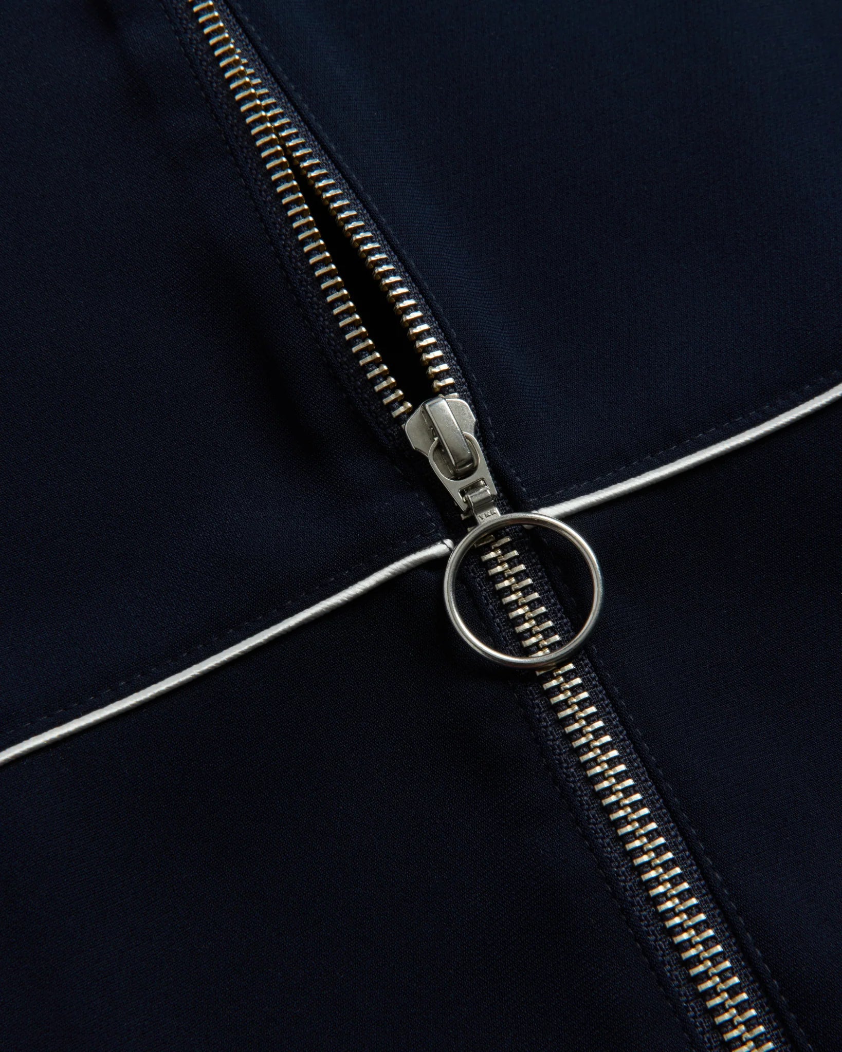Close-up of a zipper on a dark fabric background