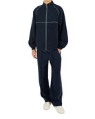 Man wearing a navy tracksuit on a white background
